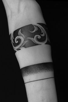 a black and white photo of a wrist tattoo with an abstract design on it's arm