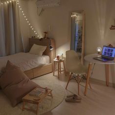 a bedroom with a bed, desk and laptop computer on the table in front of it