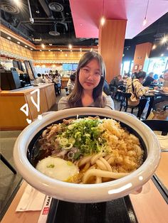 a woman sitting in front of a large bowl of food