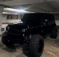 a black jeep parked in a parking garage