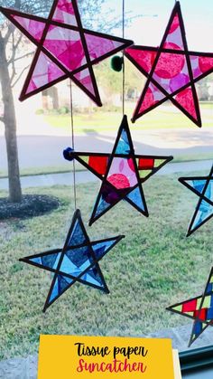 some paper stars hanging from a window with the words tissue paper sun catcher on it