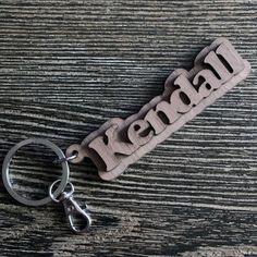 a wooden keychain with the word kennel on it sitting on a table