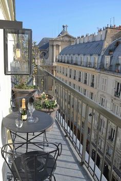 a balcony with tables and chairs on the side of it, overlooking an old building