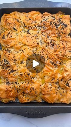 a pan filled with bread and sprinkles on top of a white table