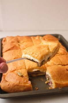 a person is cutting into a sandwich on a pan with a knife and fork in it