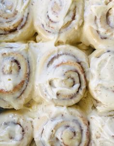 cinnamon rolls with white icing on a plate