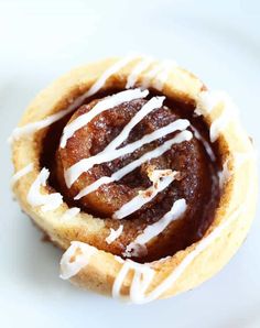 a pastry with white icing on it sitting on a plate