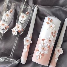 three wine glasses with flowers on them sitting next to each other