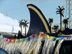 there are many decorations on the back of a truck that is decorated with palm trees and streamers