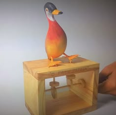 a toy bird sitting on top of a wooden box