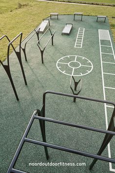 an empty basketball court with benches on the side and grass in the backgroud