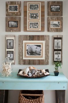 a room with pictures on the wall and an arrangement of shells in front of it