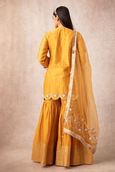 Mustard yellow straight short kurta with floral motif work and scallop hem. Comes with sharara pants and organza fringe border tassel dupatta.
Components:3
Embroidered
Neckline:V Neck
Sleeve Length:Three Quarter
Fabric:Chanderi, Organza
Color:Yellow
Fringe border dupatta
Side slits
Scallop hem
Short kurta
Tassel dupatta - Aza Fashions Tassel Dupatta, V Neck Kurta, Sharara Pants, Kurta Sharara Set, Kurta Sharara, Short Kurta, Scallop Hem, Sharara Set, Embroidered Neckline