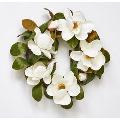 a wreath made out of white flowers and green leaves