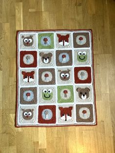 a crocheted rug with animals on it sitting on the floor in front of a wooden floor