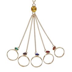 four rings with different colored stones hanging from it's sides, on a chain