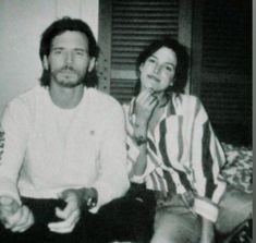 an old photo of two people sitting on a couch