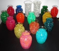 there are many vases on the table with different colors and sizes in them,