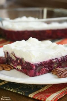 a piece of pie with whipped cream and cherries on it sitting on a plate