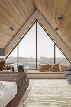 a bed sitting under a window next to a wooden wall and floor covered in pillows