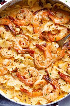 a skillet filled with pasta and shrimp