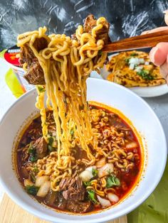 someone is lifting noodles out of a bowl