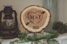 a wood slice with a heart and arrow on it next to an old fashioned lantern