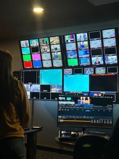 a woman standing in front of multiple monitors