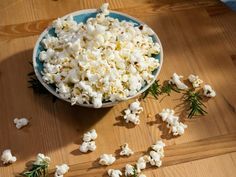 a bowl filled with popcorn sitting on top of a wooden table