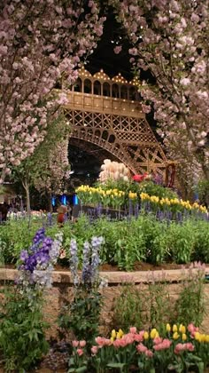 the eiffel tower is surrounded by flowers and trees