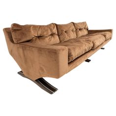 a brown couch sitting on top of a wooden stand