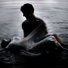 a woman is floating in the water with her dress flowing over her body and head