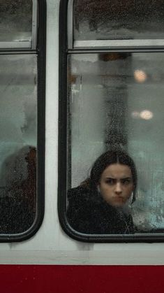 a woman looking out the window of a train