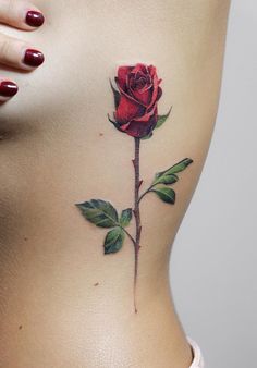 a woman's stomach with a rose tattoo on it