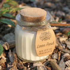 a jar filled with white liquid sitting on top of wood chips