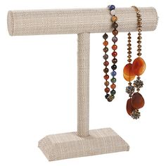 a wooden stand with several beads hanging from it's sides and two necklaces on each end