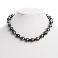 This one-of-a-kind necklace is composed of gorgeous drop-shaped Tahitian pearls measuring 12.0-12.9 mm in size and is approximately 18 inches in length. The pearls feature dark bodycolor with tones of dark green and dark silver. Your Tahitian strand will arrive double knotted on black silk. The knotting protects your pearls from rubbing against each other, and if your necklace ever breaks, you won't lose a single pearl. The necklace is finished with a solid, 14 karat clasp with a safety catch fo Formal Single Strand Teardrop Pearl Necklace, Formal Black Tahitian Pearl Necklaces, Tahitian Pearl Drop Necklace With Round Beads, Formal Black Tahitian Pearl Necklace, Luxury Tahitian Pearl Drop Necklaces, Black Tahitian Pearl Necklaces With Round Beads, Black Tahitian Pearl Round Bead Necklaces, Black Tahitian Pearl Necklace With Round Beads, Black Tahitian Pearl Necklace