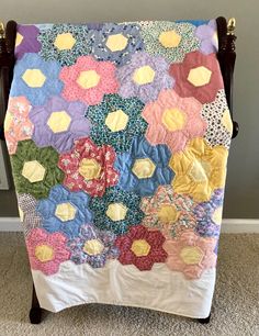 a colorful quilt on a wooden chair in a room