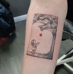 a person with a red dot on their arm holding up a tree and an apple