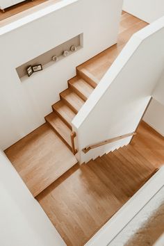 an overhead view of a stair case in a house with wood floors and white walls