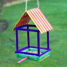 a colorful bird feeder hanging from a chain