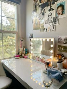 a vanity with lights on it in front of a window and a chair next to it