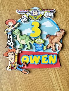 a wooden table topped with cartoon characters on it's sides and the number three