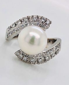 Visit My eBay Store: Amin Jewelers Very beautiful 18k solid white gold natural diamond and pearl women's ring Weight: 7.8 grams Size: 6.5 and sizable Width at the top appx: 16 mm Total diamond weight appx: 0.50 Ct Clarity: SI1 Color: G Pearl size appx: 9.3 mm COMES IN A NICE GIFT BOX! YOUR SATISFACTION IS GUARANTEED! Please add me to your Favorites list CLICK HERE FOR MORE ENGAGEMENT & WEDDING RINGS Please review the description, item condition and pictures carefully before shopping, Thank you! Diamond White Pearl Ring With Center Stone, Round Cut, Diamond White Pearl Ring With Center Stone, Classic Round Bypass Ring With Tension Setting, Classic White Bypass Ring For Formal Occasions, Classic White Gold Pearl Ring With Vvs Clarity, Classic White Diamond Bypass Ring, Formal White Gold Bypass Ring With Center Stone, Diamond White Round Bypass Ring For Formal Occasions, Formal Round Bypass Ring In Diamond White