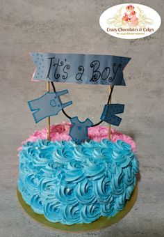 a blue and pink birthday cake with it's a boy sign on top