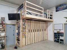 a loft bed made out of wooden pallets in a garage with shelves and tools