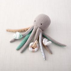 an octopus stuffed animal laying on top of a bed