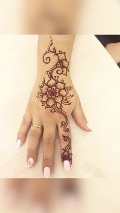 a woman's hand with henna tattoos on it