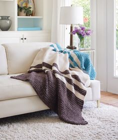 a white couch with a blanket on top of it