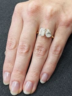 a close up of a person's hand with a diamond ring on their finger